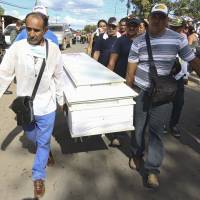 Relatives of a dead miner carry a coffin during a tribute prior to their burial in Tumeremo in Bolivar state, Venezuela, Wednesday. | REUTERS