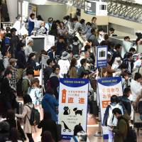 People wait at the ANA counter at Haneda airport on March 22. Staff from Haneda, Narita and Kansai airports said that they already operate at a heightened level of security and therefore do not plan to introduce fresh measures at the moment. Japan airport operators step up security, but analysts warn of vulnerabilities