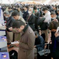 Travelers line up at check-in consoles at Haneda Airport on Tuesday morning after a glitch in ANA\'s reservation system glitch temporarily grounded dozens of domestic flights. | KYODO