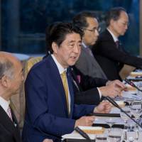 Prime Minister Shinzo Abe (second from left), accompanied by his delegation, speaks during a dinner meeting at the Japanese ambassador\'s residence in Washington on Wednesday. | AP