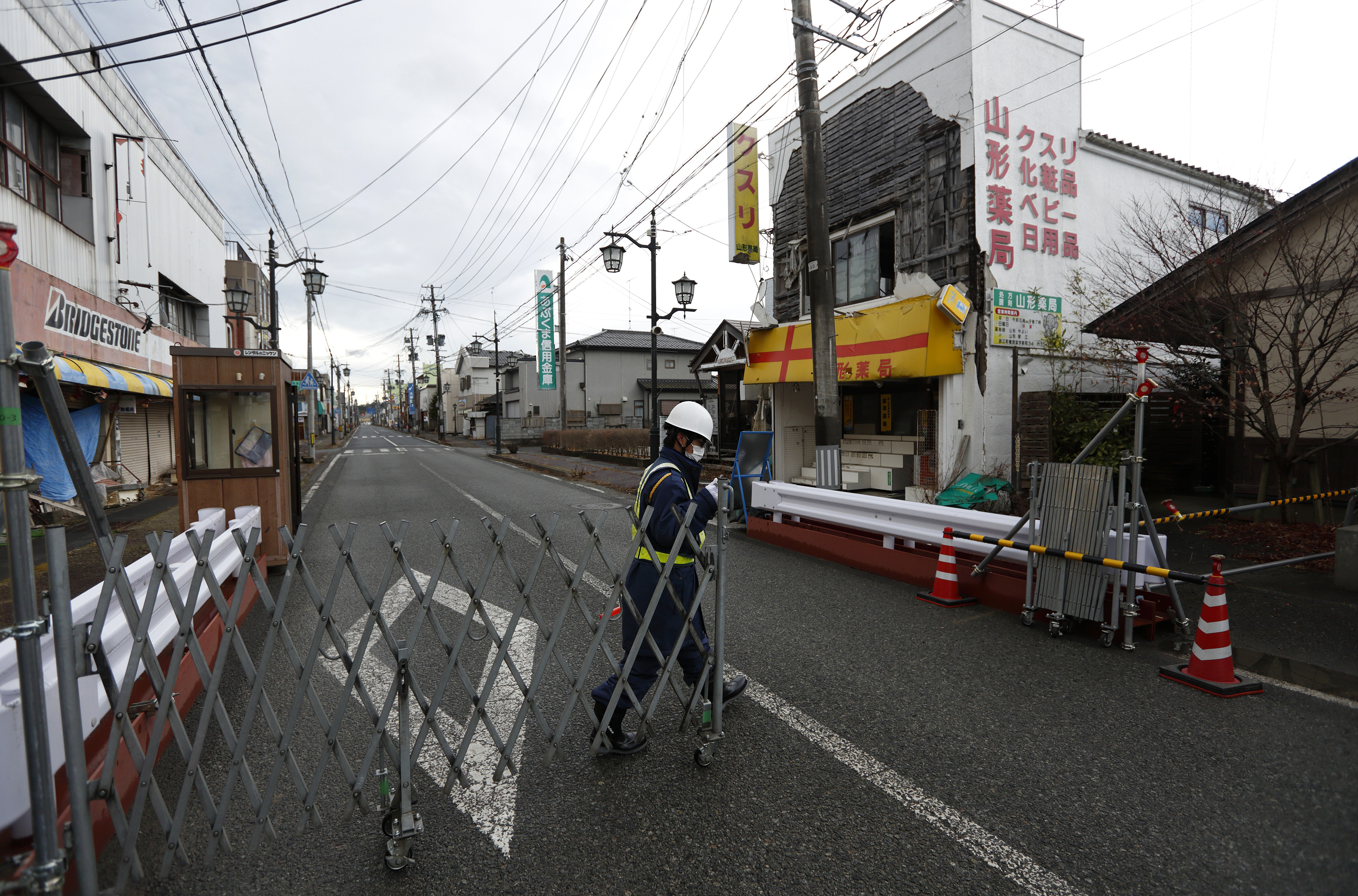 A gate is shut at the evacuation zone in Namie, Fukushima Prefecture, on Feb. 14. In such places, the scars are still obvious and many evacuees who fled are unwilling to return. | BLOOMBERG