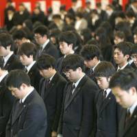 Graduating students of Takata High School in Rikuzentakata, Iwate Prefecture, offer prayers to the March 2011 victims during a graduation ceremony on Tuesday. | KYODO