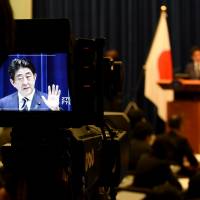 A cameraman focuses on Prime Minister Shinzo Abe during a news conference on Tuesday, when two divisive security laws punctured Japan\'s pacifist postwar defense profile. | AFP-JIJI