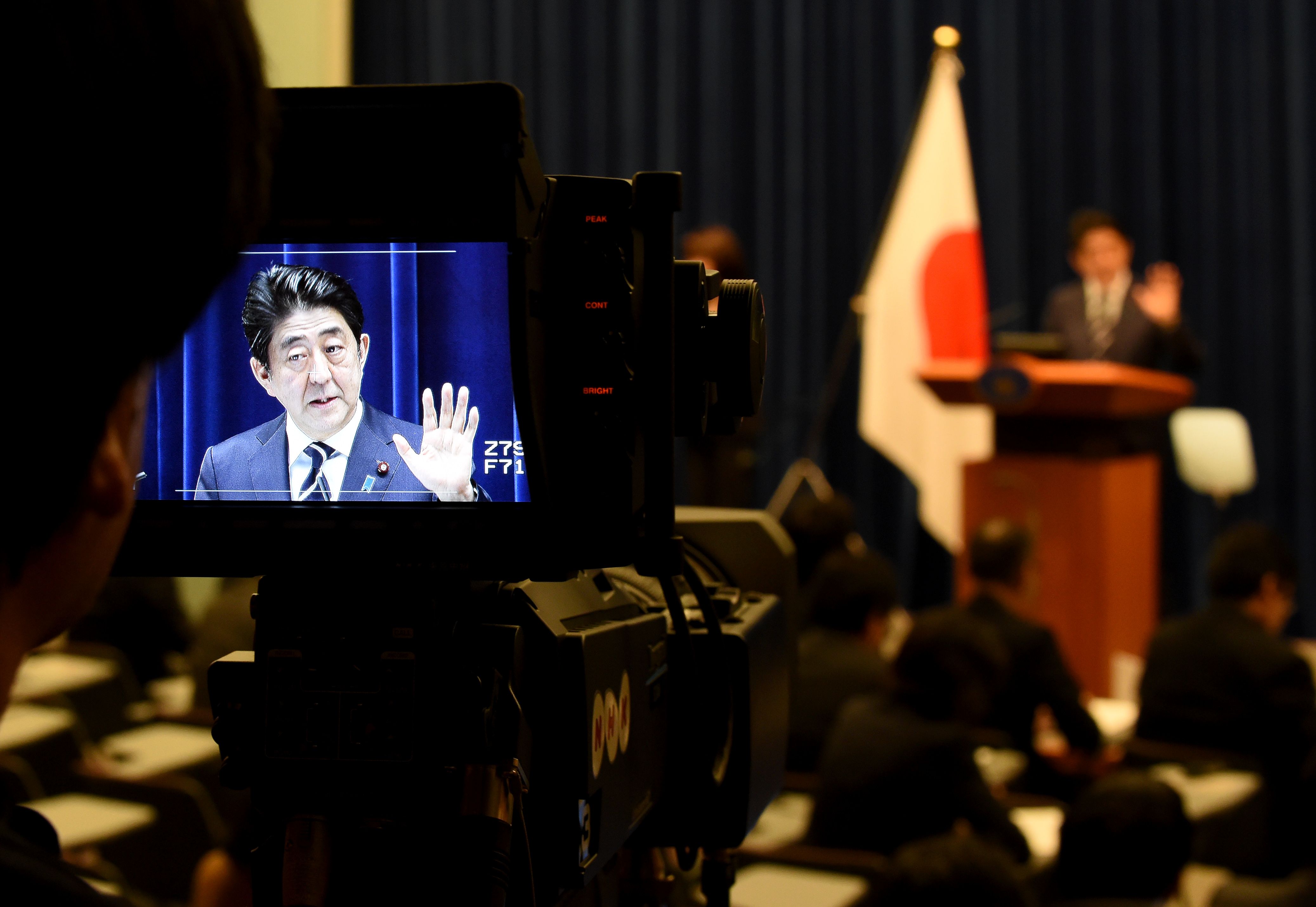 A cameraman focuses on Prime Minister Shinzo Abe during a news conference on Tuesday, when two divisive security laws punctured Japan's pacifist postwar defense profile. | AFP-JIJI