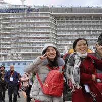 Chinese tourists arrive at Fukuoka port on a cruise passenger ship last month. A Chinese tourist was found to have been illegally working as a tour guide in the city. | KYODO