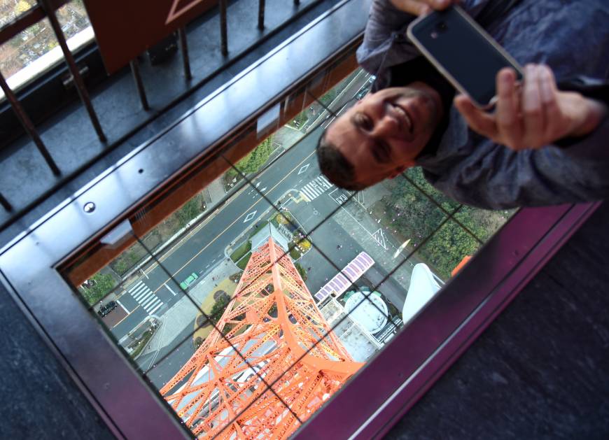 A man takes a photo with his smartphone from the observation deck of Tokyo Tower in Minato Ward last Thursday.
