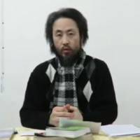 A man who appears to be Jumpei Yasuda, a journalist who went missing in Syria last year, is seen speaking in this screen shot of a video uploaded to Facebook on Thursday. | FACEBOOK