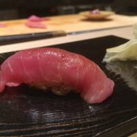 Sato\'s signature series of different cuts of tuna comprises <em>akami</em>, which has been briefly marinated in soy sauce; followed by the lighter-colored, creamier <em>chū-toro</em> (above); and finally the richly marbled, fatty <em>ōtoro</em> meat.  | ROBBIE SWINNERTON
