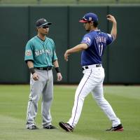 The Mariners\' Norichika Aoki (left) speaks with Rangers pitcher Yu Darvish before a spring training game on Sunday in Surprise, Arizona. | AP