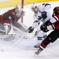 Arizona goalie Mike Smith and teammate Viktor Tikhonov defend against San Jose’s Joe Pavelski on Thursday night. Crosby stars as Penguins rally past 'Canes