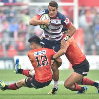 Melbourne\'s Mitch Inman is tackled by the Sunwolves\' Yu Tamura (left) and Shota Horie in their Super Rugby match at Prince Chichibu Memorial Rugby Ground on Saturday. | AFP-JIJI