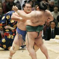 Kotoshogiku (left) pushes Takayasu out of the ring on the first day of the Spring Grand Sumo Tournament in Osaka on Sunday. | KYODO