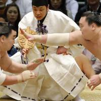 Hakuho (right) reaches out with his hand at the start of his bout against Harumafuji at the Spring Grand Sumo Tournament in Osaka on Sunday. | KYODO