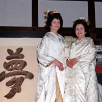 The \"Kitsune no Yomeiri\" (Wedding Parade of the Foxes), featuring women wearing white kimono and made up to look like foxes, is currently underway in Kyoto. Dace Penke (left), the wife of the Latvian ambassador, and Monica Riquetti Ulloa, the wife of the Uruguayan ambassador, pose in kimono at Kodaji Temple on March 12. The event runs through March 21. | TAKAHIRO HAYASHI