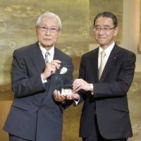 \"Hotelier of the Year, 2015,\" Yasushi Minami (right), managing director and general manager of the Royal Park Hotel receives an award recognizing his achievements from Yasunari Ebihara (left), a representative of a hotel industry association, on March 16 at the Royal Park Hotel. | HIROKO INOUE