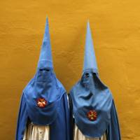 Penitents of the San Esteban brotherhood pose before a Holy Week procession on Tuesday in Seville, southern Spain. The robes are designed to let the faithful repent their sins in anonymity. | REUTERS
