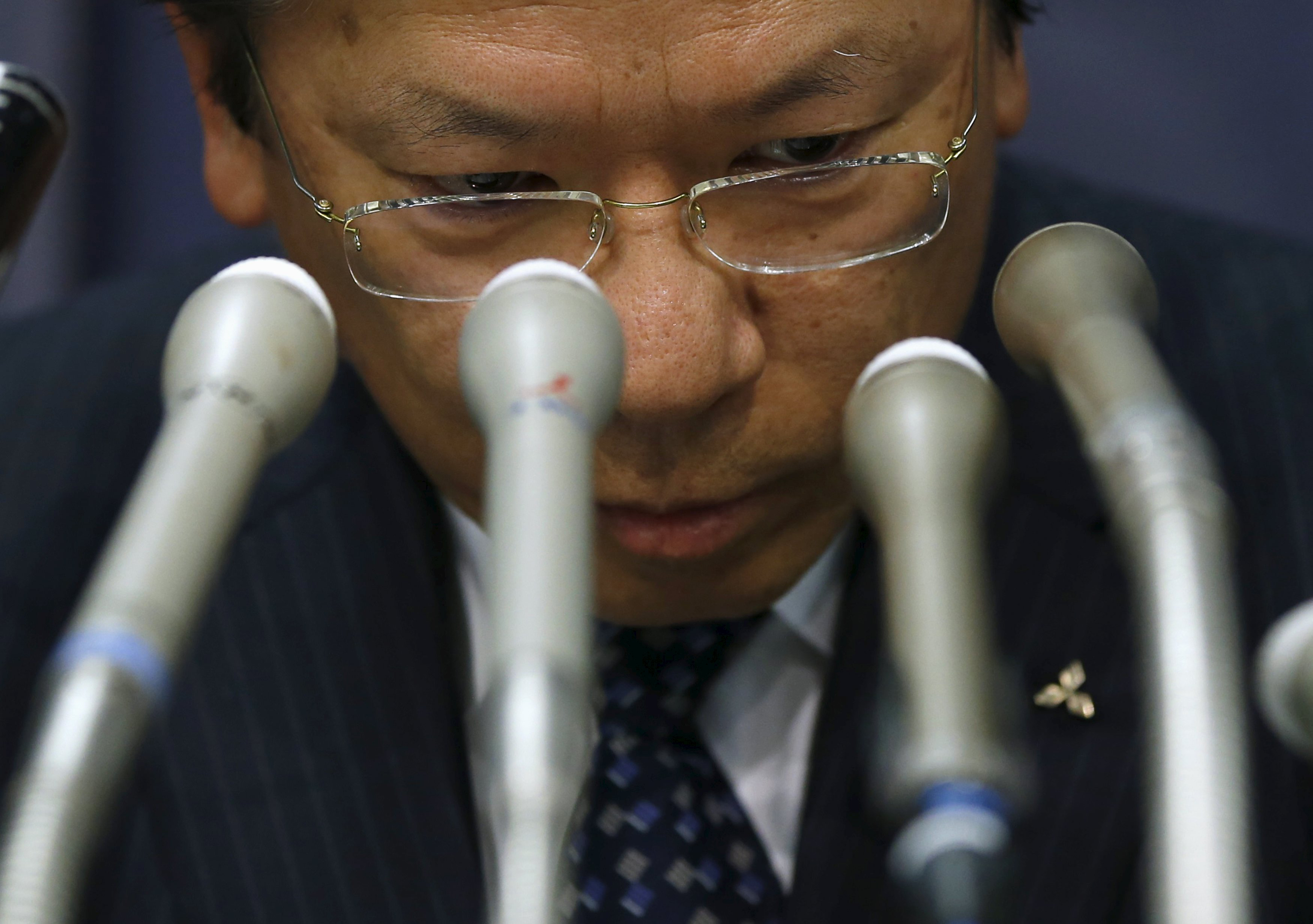 Mitsubishi Motors Corp. President Tetsuro Aikawa faces the media at a news conference Wednesday at the transport ministry over the automaker's misconduct related to fuel-efficiency tests. | REUTERS