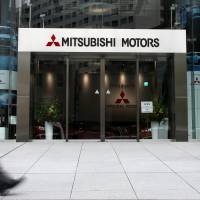 A man walks past the entrance of Mitsubishi Motors headquarters in Tokyo on April 27. | REUTERS