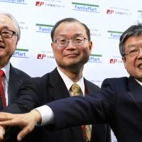Japan Post Holdings Co. President Masatsugu Nagato (left) poses for a photo with Japan Post Co. President Toru Takahashi (center) and Japan Post Bank Co. President Norito Ikeda during a joint news conference held Tuesday with FamilyMart Co. on their business tieup in Tokyo. | REUTERS