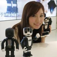 A woman poses with Sharp’s humanoid RoBoHon smartphone on Thursday at a Sharp’s Tokyo office. The product hits stores on May 26. | KAZUAKI NAGATA