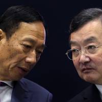 Terry Gou, chairman of Foxconn Technology Group (left), exchanges words with Kozo Takahashi, president of Sharp Corp., at a news conference in Osaka on April 2. | BLOOMBERG