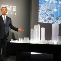 Mori Building CEO Shingo Tsuji poses in front of a model of his firm\'s redevelopment plan for the Toranomon area of Tokyo on Wednesday in the capital. | KAZUAKI NAGATA