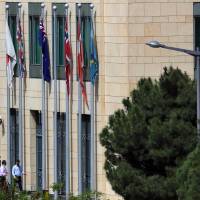 Two employees enter a compound that houses the Australian Embassy in Beirut on Thursday. Lebanese authorities have detained four Australians, including journalists, on suspicion they were involved in the abductions of two children in the capital. Four Australians detained in Lebanon on kidnapping suspicion
