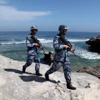 China\'s People\'s Liberation Army Navy soldiers patrol on Woody Island, in the Paracel archipelago of the South China Sea, in January. | REUTERS