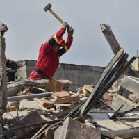 Peruvian rescuers search for survivors under the rubble in Manta, in the Ecuadorean coastal province of Manabi, on Monday, two days after a 7.8-magnitude quake hit the country. Rescuers and desperate families clawed through the rubble Monday to pull out survivors of an earthquake that killed 350 people and destroyed towns in a tourist area of Ecuador. | AFP-JIJI