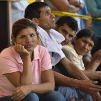 People wait for news of their loved ones in Manta, in the Ecuadorean coastal province of Manabi, on Monday. | AFP-JIJI