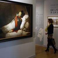 A visitor looks at “Napoleon I on his deathbed, one before to be buried” painting of Jean Baptiste Mauzaisse during a visit of the exhibition “Napoleon in St. Helena” at Les Invalides museum in Paris on Tuesday. Napoleon's last home on St. Helena is re-created for Paris exhibition