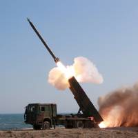 A new large-caliber multiple rocket launcher is demonstrated, with North Korean leader Kim Jong Un in attendance, in this photo released on March 22. | REUTERS