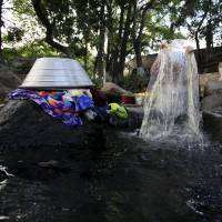 A woman washes clothes at Las Tres Piedras river in Nejapa, El Salvador, on March 2. | REUTERS