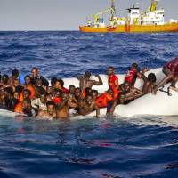 Migrants ask for help from a dinghy Sunday as they are approached by the SOS Mediterranee ship Aquarius off the coast of the Italian island of Lampedusa. Survivors say panic during boat transfer caused up to 500 migrants to drown in Mediterranean last week