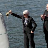Dr. Arati Prabhakar, director of DARPA, christens the autonomous ship Sea Hunte\", developed by DARPA as Robert Work (second. right), U.S. deputy secretary of defense, looks on Thursday in Portland, Oregon. | REUTERS