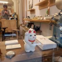 A maneki neko (beckoning cat) figure is displayed in the window of a store near Gotokuji Temple in Tokyo\'s Setagaya Ward on March 12. | YOSHIAKI MIURA