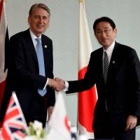 British Foreign Secretary Philip Hammond and Foreign Minister Fumio Kishida shake hands prior to their bilateral meeting in Hiroshima on Sunday. | POOL/AFP-JIJI
