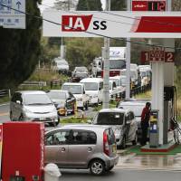 A long line of vehicles wait Monday at a gas station in Aso, Kumamoto Prefecture, after two deadly earthquakes disrupted utilities in the region. | KYODO