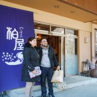 Visitors take a photo in front of a ryokan style inn in Gunma. While the government plans to facilitate construction of more hotels, it also hopes that such traditional inns will prove popular for inbound tourists. | KYODO