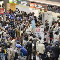 The departure lobby for domestic flights at Haneda airport in Tokyo is thronged last Friday as Japan Airlines flights are canceled due to a system glitch. | KYODO