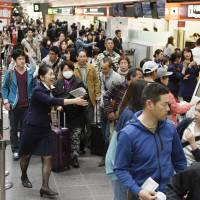Frustrated passengers flock to Japan Airlines\' counters in Haneda airport Friday morning after a problem with the carrier\'s computer system led to the cancellation of some flights. | KYODO