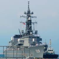 A tug guides the guided-missile destroyer Ariake in Vietnam\'s Cam Ranh Bay on Tuesday. | KYODO
