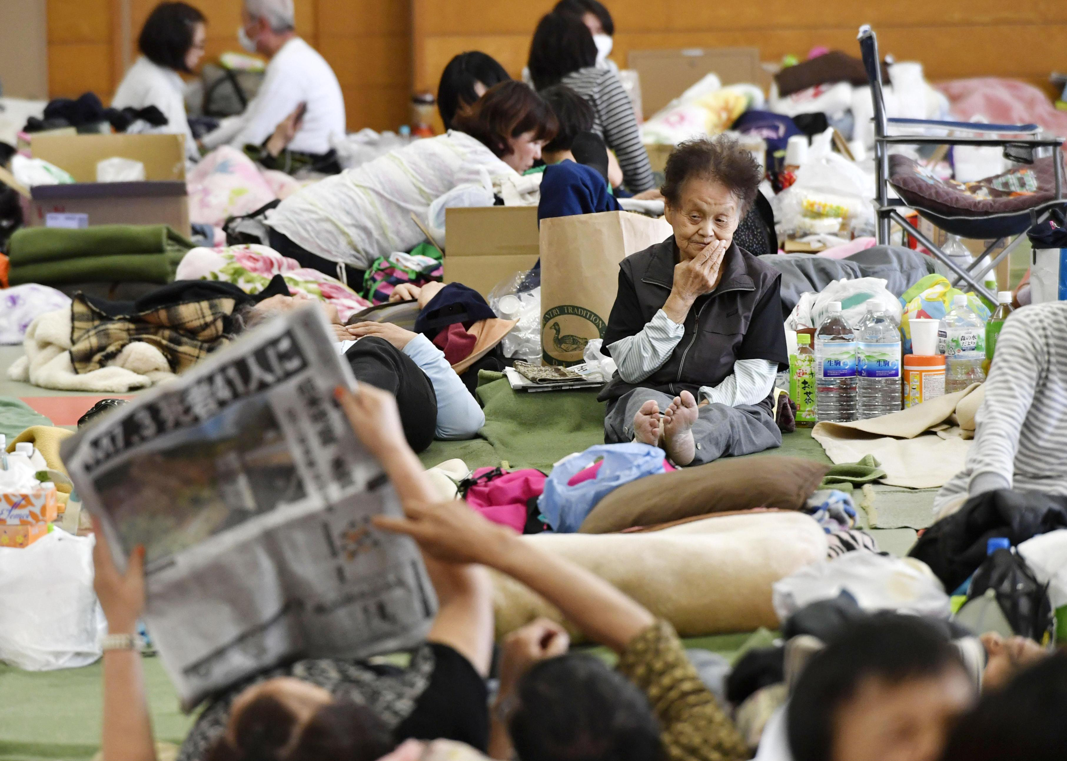 Displaced residents in Kumamoto Prefecture rest Sunday at an earthquake evacuation center set up at an elementary school in Yufu, Oita Prefecture. | KYODO