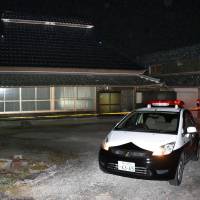 A police officer guards a house in Kato, Hyogo Prefecture, where a 79-year-old woman was found strangled Tuesday. | KYODO