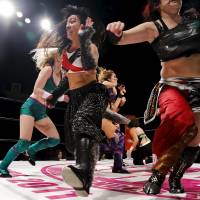 Wrestler Kris Wolf (center) and fellow wrestlers scatter across the ring during their wrestling show in Tokyo. | REUTERS