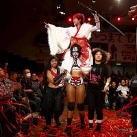 Wrestlers Kris Wolf and Kimura Kyoko carry their fellow fighter Act Yasukawa after her last match before retirement on Dec. 23, 2015. | REUTERS