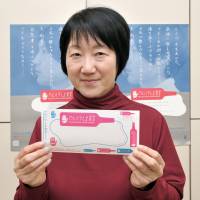 ASK Chairwoman Tomomi Imanari holds educational material. | YOSHIAKI MIURA