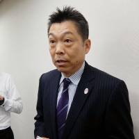Nippon Badminton Association chief executive Kinji Zeniya speaks to reporters on Monday. | KYODO