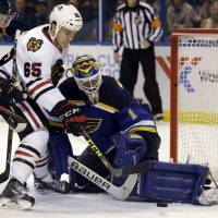 The Blackhawks’ Andrew Shaw (left) scores past Blues goalie Brian Elliott during the third period of their playoff game on Friday in St. Louis. Chicago won 3-2 to even the first-round series at 1-1. Shaw strikes late to lift Chicago