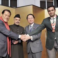 Pakistan Ambassador Farukh Amil (second from left) shakes hands  with, from left, House of Councillors member Antonio Inoki; President of the Japan-Pakistan Parliamentarians\' Friendship League Seishiro Eto; and judoka Shah Hussain, a Tsukuba University student and a member of the Pakistan National Judo Team, during a reception to celebrate the country\'s National Day at the New Otani Hotel in Tokyo on March 23. | YOSHIAKI MIURA